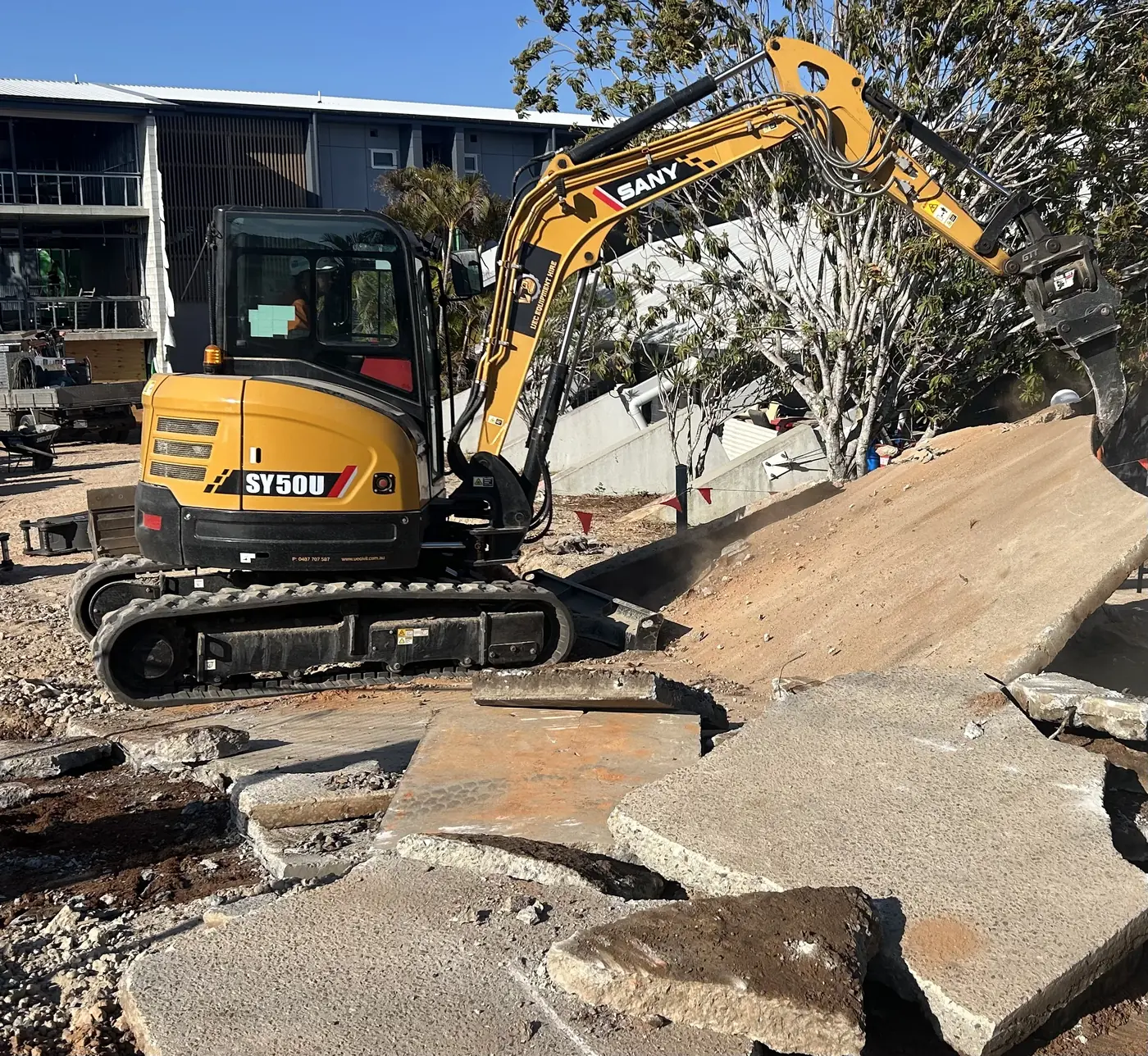 SANY SY50U excavator performing concrete demolition and site preparation on a construction site in Brisbane